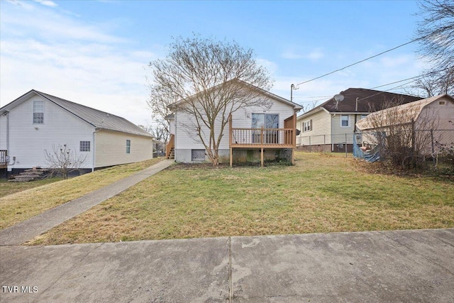 back of property featuring a deck and a lawn