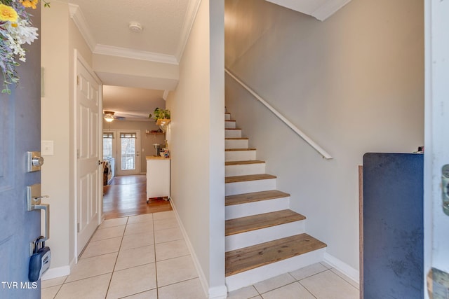 stairway with tile patterned flooring, ornamental molding, and ceiling fan