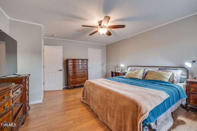 bedroom with ornamental molding, ceiling fan, a textured ceiling, and light hardwood / wood-style flooring