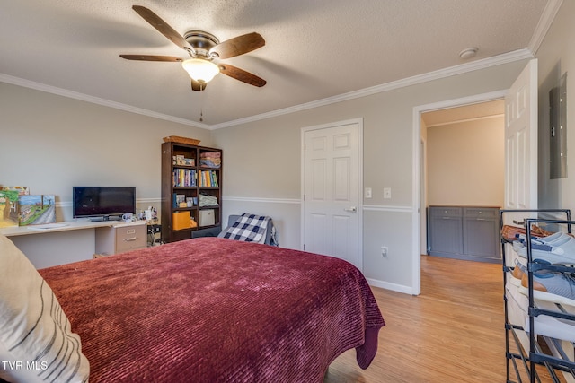 bedroom featuring ornamental molding, electric panel, ceiling fan, light hardwood / wood-style floors, and a textured ceiling