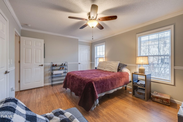 bedroom featuring wood-type flooring, ornamental molding, a closet, and a textured ceiling