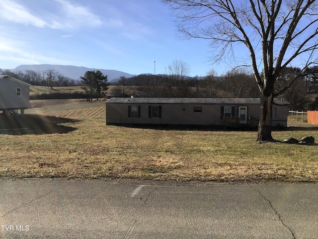 view of front of home with a mountain view and a front yard