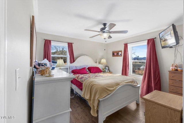 bedroom with crown molding, dark wood-type flooring, and ceiling fan