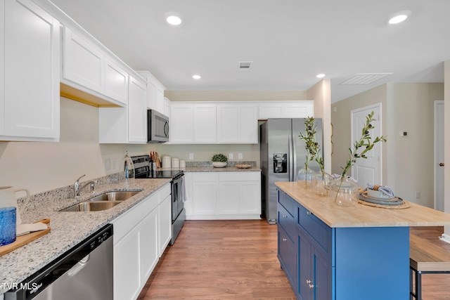 kitchen featuring blue cabinets, appliances with stainless steel finishes, sink, and white cabinets