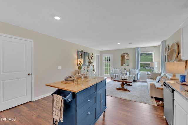 kitchen featuring blue cabinets, butcher block counters, stainless steel dishwasher, dark hardwood / wood-style floors, and white cabinets