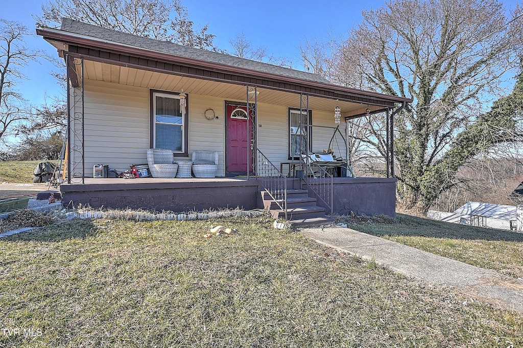 view of front of property featuring covered porch and a front lawn