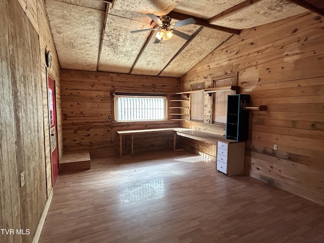 interior space with dark hardwood / wood-style flooring, lofted ceiling with beams, ceiling fan, and wood walls