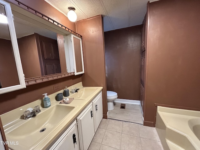 bathroom with vanity, tile patterned floors, toilet, and a textured ceiling