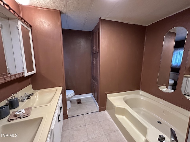 bathroom featuring tile patterned floors, toilet, a textured ceiling, vanity, and a bathing tub