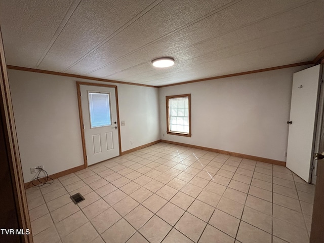 unfurnished room with crown molding, light tile patterned floors, and a textured ceiling