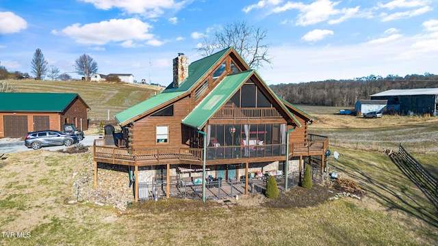 rear view of house featuring a sunroom and a deck