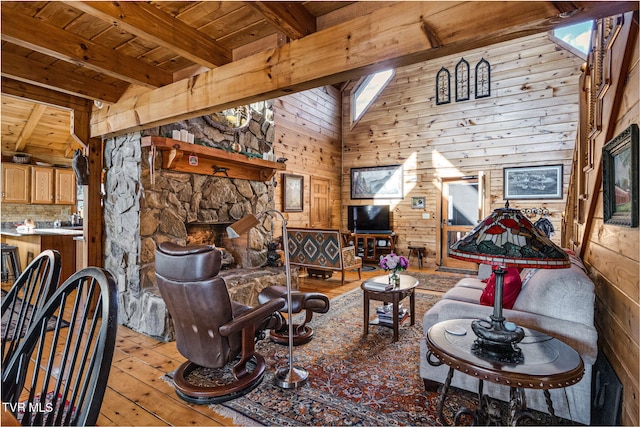 sitting room with beam ceiling, wood walls, wood ceiling, light hardwood / wood-style flooring, and a fireplace