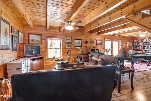 living room featuring beam ceiling, wood walls, wood ceiling, and light hardwood / wood-style floors