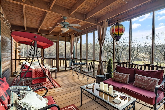 sunroom with ceiling fan, a wealth of natural light, wooden ceiling, and beam ceiling