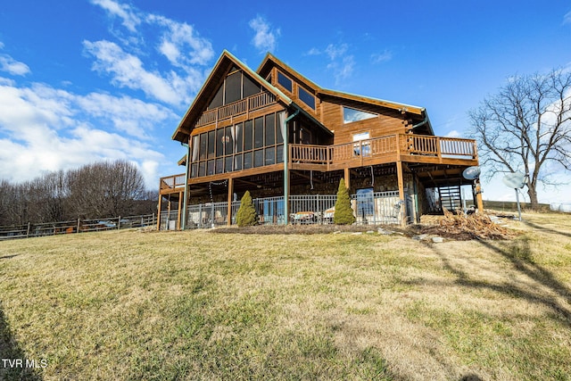 rear view of property featuring a yard and a sunroom