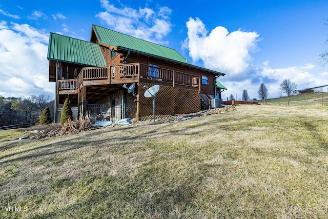 rear view of property with a yard and a deck