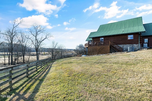 view of yard with central AC, a deck, and a rural view