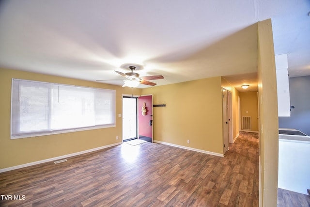 spare room featuring dark wood-type flooring and ceiling fan