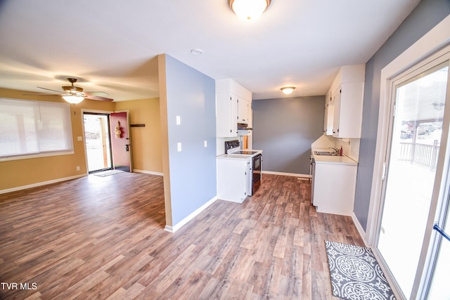 kitchen with ceiling fan, white cabinets, wood-type flooring, and electric range