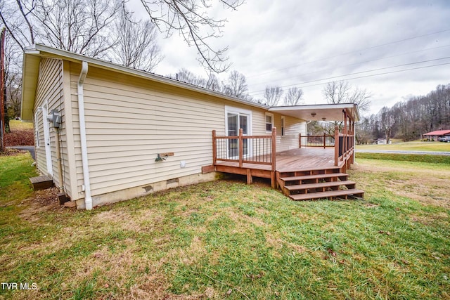 rear view of property featuring a deck and a lawn