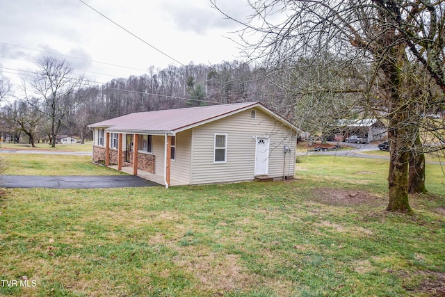 view of side of home with a porch and a lawn