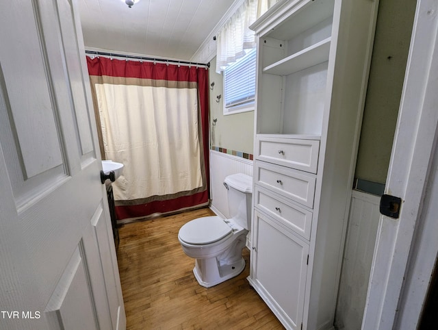 bathroom with hardwood / wood-style flooring and toilet