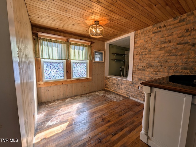 unfurnished dining area featuring wood ceiling, dark hardwood / wood-style floors, and an inviting chandelier