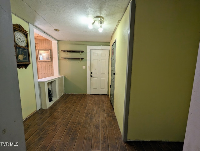 hallway featuring dark hardwood / wood-style floors and a textured ceiling