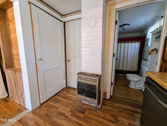 corridor featuring heating unit and dark hardwood / wood-style floors