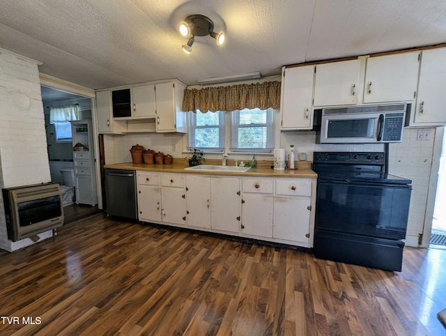 kitchen featuring sink, dark wood-type flooring, white cabinetry, heating unit, and black appliances