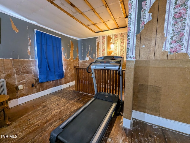 exercise area featuring dark wood-type flooring and crown molding