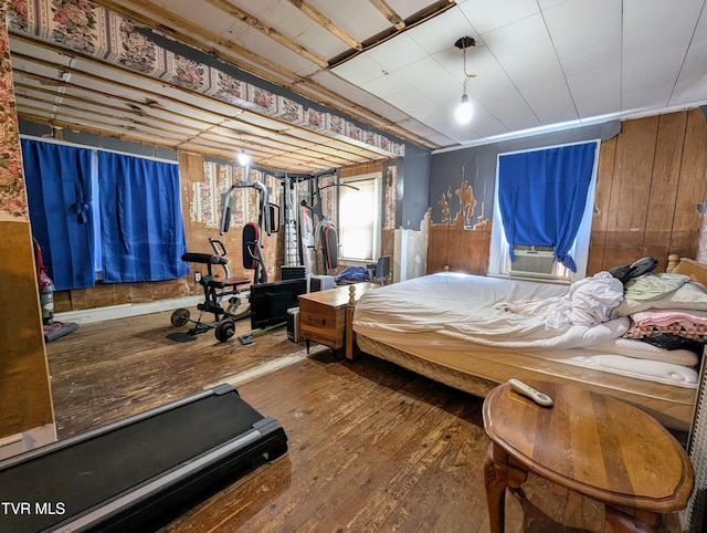 bedroom featuring hardwood / wood-style floors and wood walls