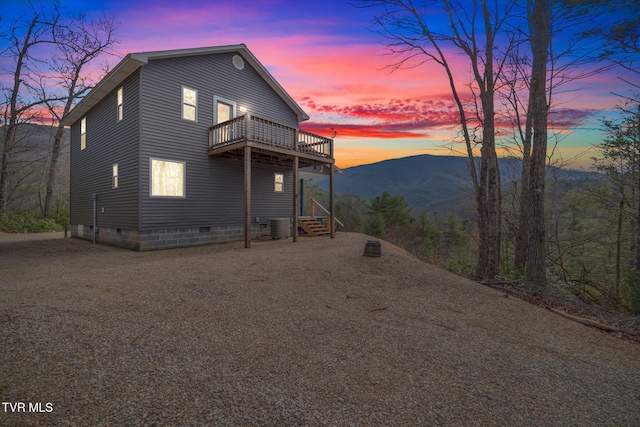 property exterior at dusk with central AC unit and a mountain view