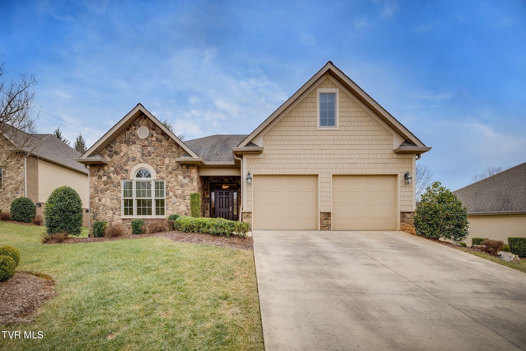 view of front of house featuring a garage and a front lawn