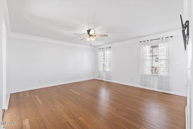 spare room featuring wood-type flooring, a healthy amount of sunlight, a textured ceiling, and ceiling fan