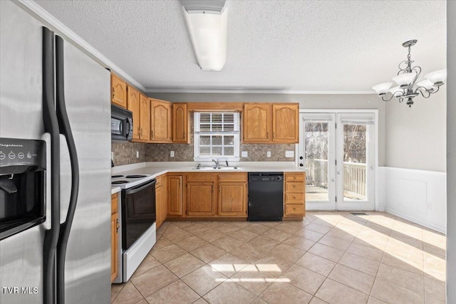 kitchen featuring sink, hanging light fixtures, light tile patterned floors, black appliances, and a textured ceiling