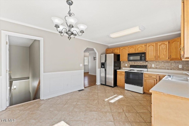 kitchen with pendant lighting, white electric stove, sink, stainless steel fridge, and crown molding