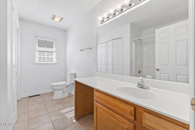 bathroom with tile patterned flooring, vanity, a textured ceiling, toilet, and walk in shower