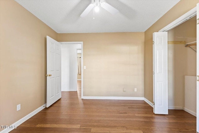 unfurnished bedroom featuring ceiling fan, hardwood / wood-style floors, and a textured ceiling