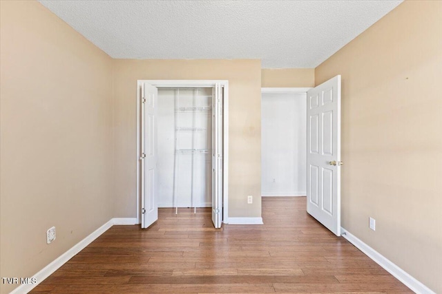 unfurnished bedroom with hardwood / wood-style floors, a closet, and a textured ceiling