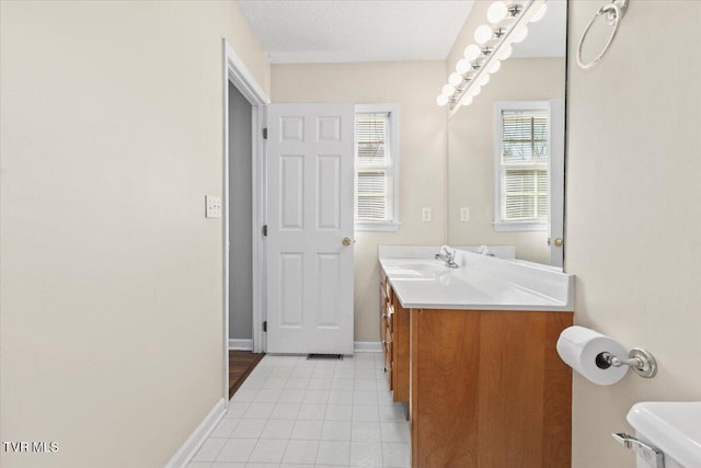 bathroom featuring vanity, tile patterned floors, and a textured ceiling