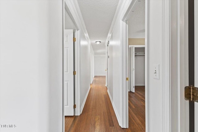 hallway with dark hardwood / wood-style floors and a textured ceiling