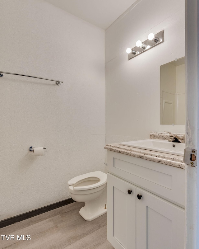 bathroom with vanity, wood-type flooring, and toilet