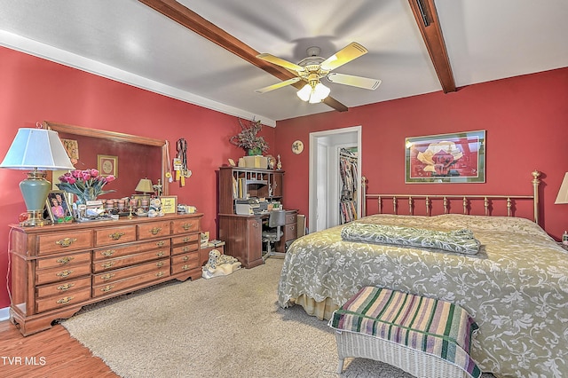 bedroom featuring ceiling fan, beam ceiling, a closet, and a spacious closet