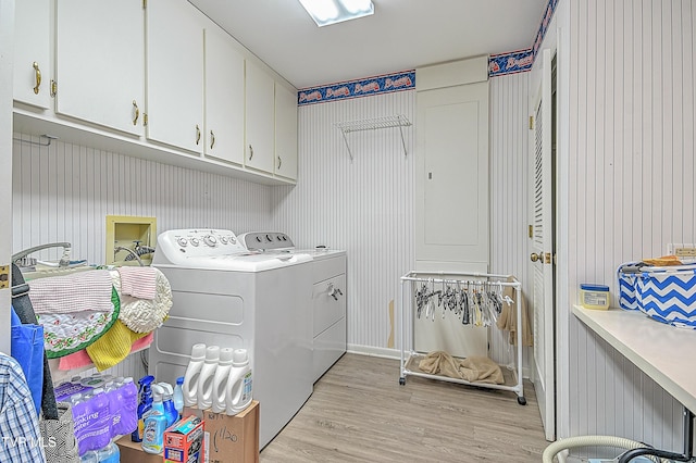 laundry area with cabinets, washer and clothes dryer, and light hardwood / wood-style floors