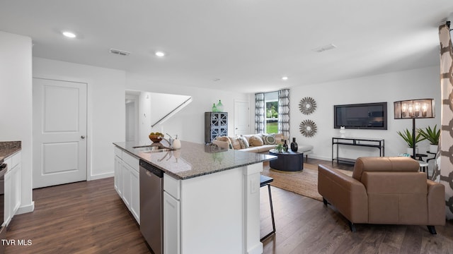 kitchen with white cabinetry, dishwasher, sink, dark stone countertops, and a center island