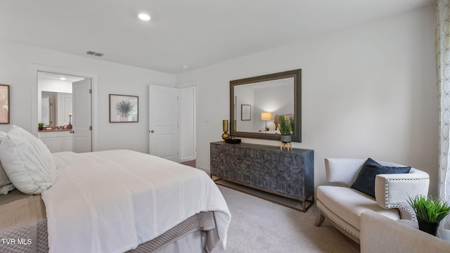 carpeted bedroom featuring ensuite bath