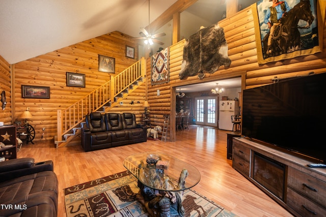 living room featuring french doors, high vaulted ceiling, hardwood / wood-style flooring, log walls, and ceiling fan with notable chandelier