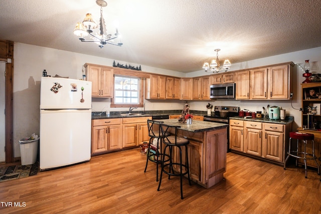 kitchen with stainless steel appliances, a center island, a notable chandelier, and a kitchen bar