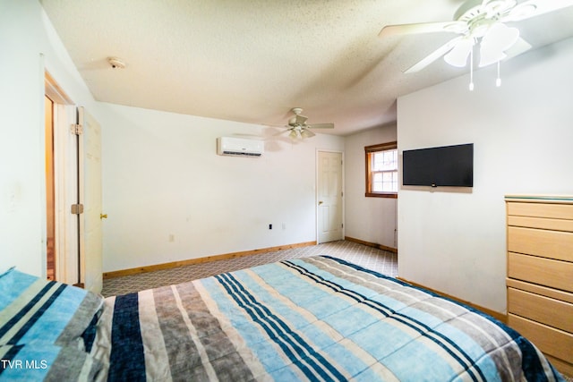 unfurnished bedroom with ceiling fan, light carpet, a wall unit AC, and a textured ceiling